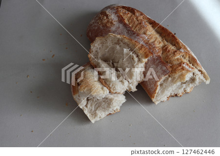 A broken freshly baked rustic baguette. A broken freshly baked rustic baguette. 127462446