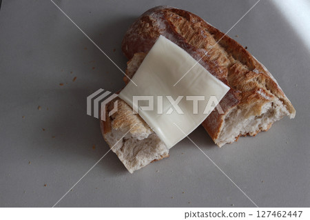 A broken baked baguette with melted cheese. 127462447
