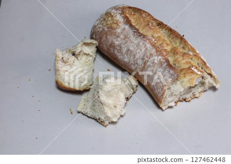 A broken freshly baked rustic baguette. 127462448