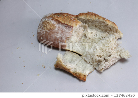 A broken freshly baked rustic baguette. A broken freshly baked rustic baguette. 127462450