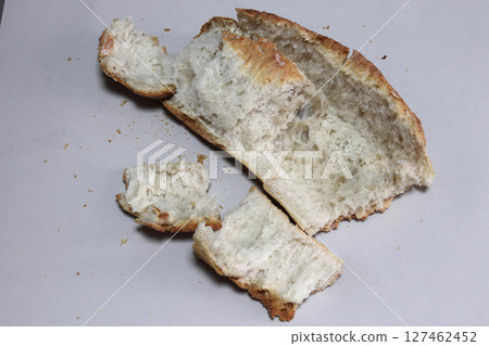 A broken freshly baked rustic baguette. A broken freshly baked rustic baguette. 127462452