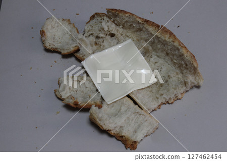 A broken baked baguette with melted cheese. 127462454