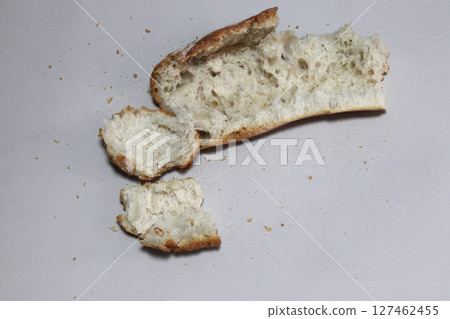 A broken freshly baked rustic baguette. A broken freshly baked rustic baguette. 127462455
