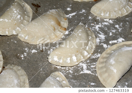 Close up of home made Chinese dim sum dumplings Jiaozi or Gyoza on bakking tray ready to be fried 127463319