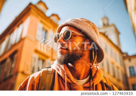 Stylish man wearing sunglasses and hat enjoying sunny day in vibrant urban setting 127463910