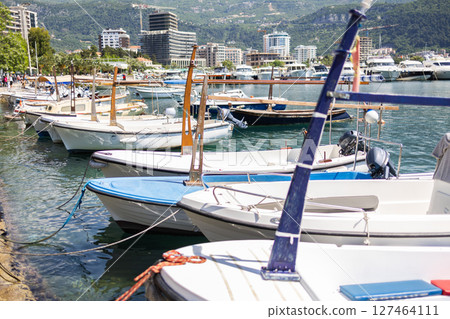 Small boats lined up at marina with modern coastal skyline in the background. Urban tourism, coastal life, and everyday boating in seaside European towns. Small boats lined up at marina with modern coastal skyline in the background. Urban tourism, coastal life, and everyday boating in seaside European towns. 127464111