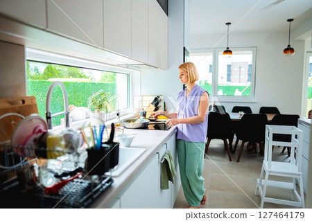 Cooking in a modern kitchen during bright daylight hours 127464179