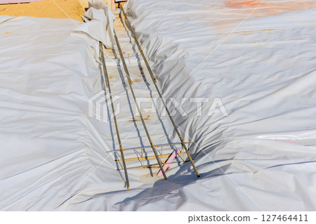 Construction site at residential development with exposed rebar vapor barrier covering foundation area Construction site at residential development with exposed rebar vapor barrier covering foundation area 127464411