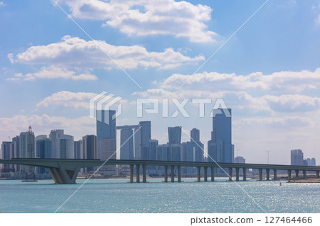 View of city with towers and skyscrapers from Saadiyat Island in Abu Dhabi, United Arab Emirates. View from water surface. High quality photo View of city with towers and skyscrapers from Saadiyat Island in Abu Dhabi, United Arab Emirates. View from water surface. High quality photo 127464466
