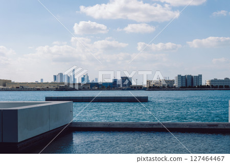 View of city with towers and skyscrapers from Saadiyat Island in Abu Dhabi, United Arab Emirates. View from water surface. High quality photo View of city with towers and skyscrapers from Saadiyat Island in Abu Dhabi, United Arab Emirates. View from water surface. High quality photo 127464467