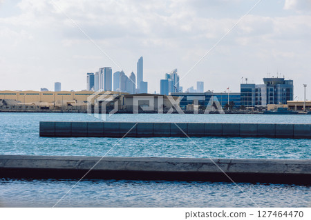 View of city with towers and skyscrapers from Saadiyat Island in Abu Dhabi, United Arab Emirates. View from water surface. High quality photo View of city with towers and skyscrapers from Saadiyat Island in Abu Dhabi, United Arab Emirates. View from water surface. High quality photo 127464470