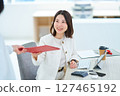 Woman talking to a colleague at work 127465192
