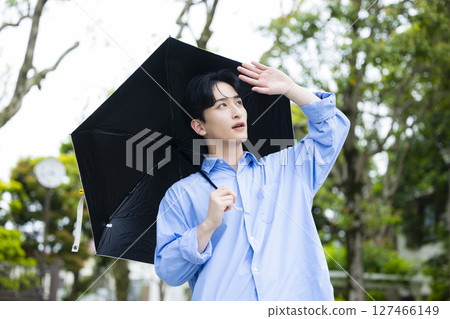 Young man holding a parasol 127466149