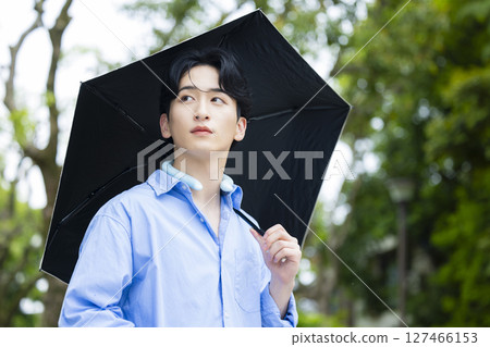 拿著遮陽傘的年輕人 拿著遮陽傘的年輕人 127466153