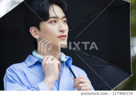 拿著遮陽傘的年輕人 拿著遮陽傘的年輕人 127466154