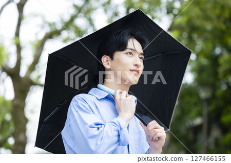 拿著遮陽傘的年輕人 127466155