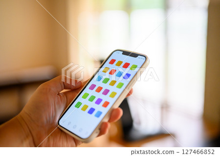 一名男子手持智慧型手機（螢幕是為拍攝而製作的原創畫面） 127466852