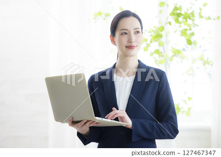 帶筆記本電腦的微笑女商人 帶筆記本電腦的微笑女商人 127467347