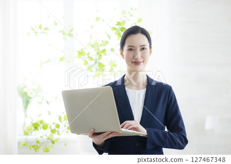 smiling businesswoman with laptop 127467348