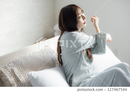 A woman stretching in bed 127467594