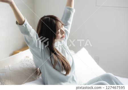 一個女人在床上伸展 一個女人在床上伸展 127467595