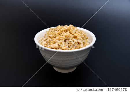 Brown rice served in a bowl on a black background Brown rice served in a bowl on a black background 127469378