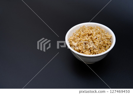 Brown rice served in a bowl on a black background Brown rice served in a bowl on a black background 127469450