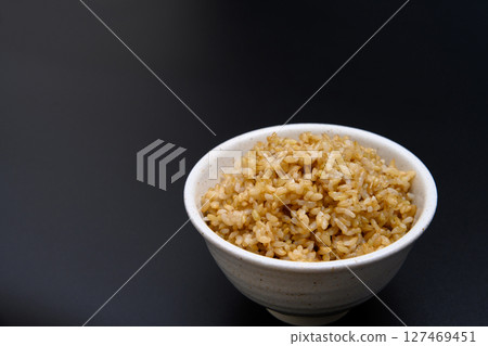 Brown rice served in a bowl on a black background Brown rice served in a bowl on a black background 127469451