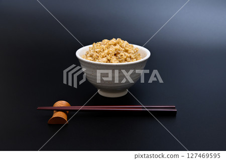 黑色背景中，碗裡盛著糙米 127469595