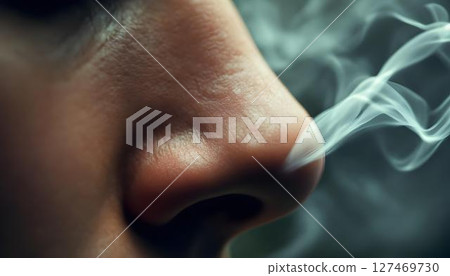 Close-up shot of a woman's face, smoke billowing from her nose, highlighting her expression and the ethereal quality of the moment 127469730