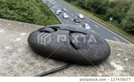 A Computer Mouse on a Ledge Overlooking a Busy Highway, Creative Juxtaposition A Computer Mouse on a Ledge Overlooking a Busy Highway, Creative Juxtaposition 127470077