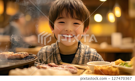 A boy smiling at a yakiniku restaurant A boy smiling at a yakiniku restaurant 127470367