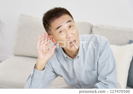 Hearing-impaired senior man living room 127470500