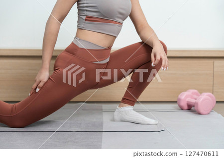 Yoga and Fitness. Close-up of a woman in a lunge stretch, focusing on form and posture. Yoga and Fitness. Close-up of a woman in a lunge stretch, focusing on form and posture. 127470611