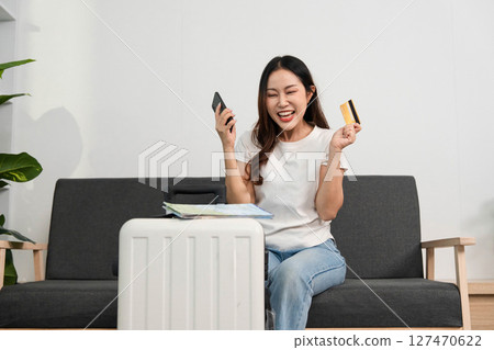 Travel Planning with Smartphone and Credit Card. Excited woman preparing for her journey. Travel Planning with Smartphone and Credit Card. Excited woman preparing for her journey. 127470622