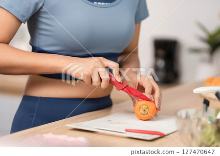 ESG and Healthy Cooking. Slicing fresh carrots in a sustainable kitchen environment. 127470647