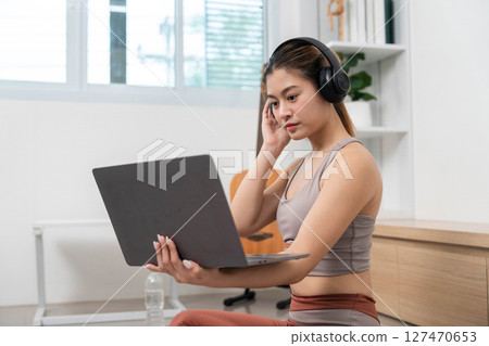 Yoga and Remote Work. Woman using laptop while practicing yoga and fitness at home. Yoga and Remote Work. Woman using laptop while practicing yoga and fitness at home. 127470653