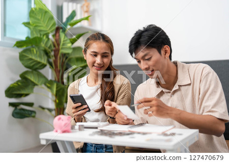 Digital Financial Management. Couple reviewing budget with smartphone and notebook. Digital Financial Management. Couple reviewing budget with smartphone and notebook. 127470679
