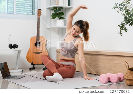Yoga Stretch and Wellness. Woman stretching during yoga practice at home for health and relaxation. Yoga Stretch and Wellness. Woman stretching during yoga practice at home for health and relaxation. 127470681