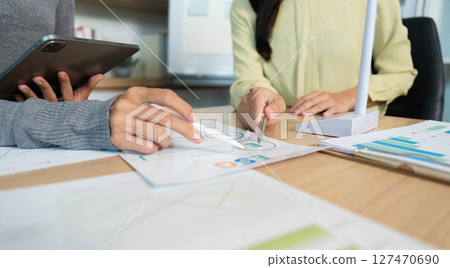 ESG Strategy Session. Professionals analyzing data and discussing sustainable initiatives. 127470690