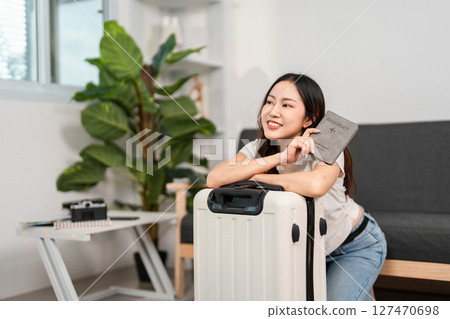 Travel Planning. Happy woman holding passport next to her suitcase. Travel Planning. Happy woman holding passport next to her suitcase. 127470698