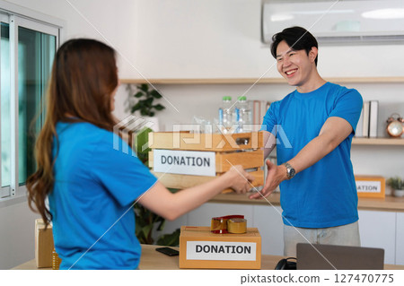 Donation Activity. Volunteers engaging in charitable giving with donation boxes. Donation Activity. Volunteers engaging in charitable giving with donation boxes. 127470775