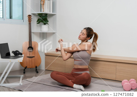 Yoga and Stretching. Woman seated, stretching arms for flexibility and wellness. Yoga and Stretching. Woman seated, stretching arms for flexibility and wellness. 127471082