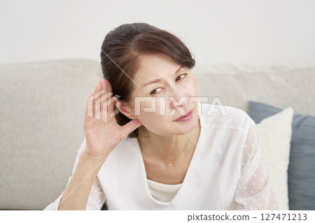Hearing-impaired senior woman in the living room Hearing-impaired senior woman in the living room 127471213