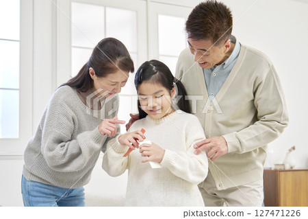 Grandmother and grandfather giving New Year's money to their grandchild Grandmother and grandfather giving New Year's money to their grandchild 127471226