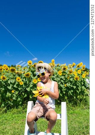 Little boy playing in sunflower field 127471552
