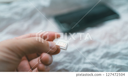 Remove the SIM card from the backing Remove the SIM card from the backing 127472504