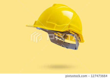 Safety construction helmet on yellow background Safety construction helmet on yellow background 127473664