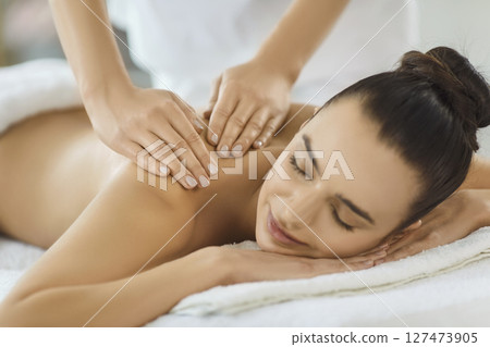 Masseuse Massaging Clients Back In Spa Salon 127473905