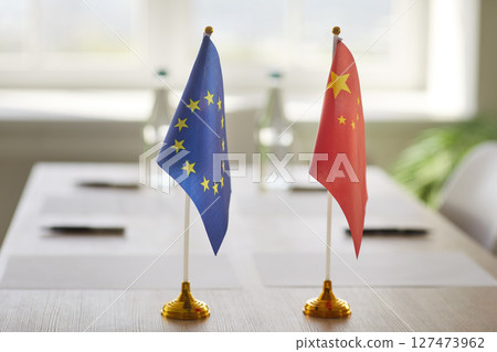 Flags of European Union and China on meeting table prepared for diplomatic negotiation or summit. 127473962